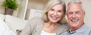 Middle age couple smiling after having restorative dental services